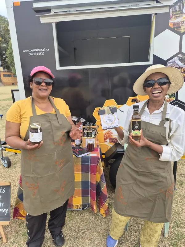 Two local honey vendors holding jars at 012 Vintage Fair