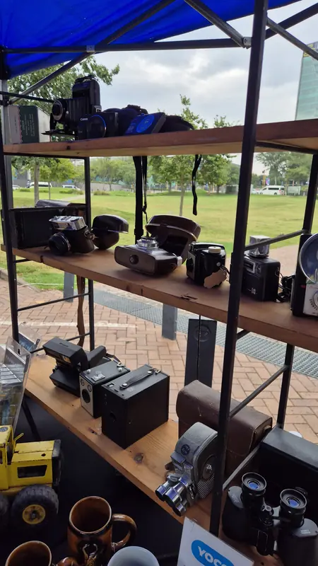 Collection of vintage cameras and binoculars at a stall